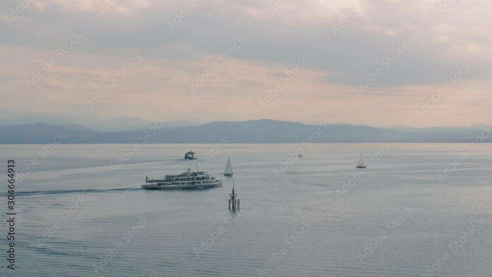 Boat and sailing yachts sail on water on lake high angle aerial view mountains on background Boat and sailing yachts sail on water on lake high angle aerial view mountains on background