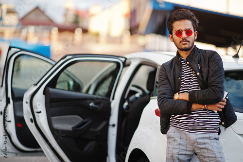 South asian man or indian male wear red eyeglasses stand near his white transportation on car wash. © AS Photo Family