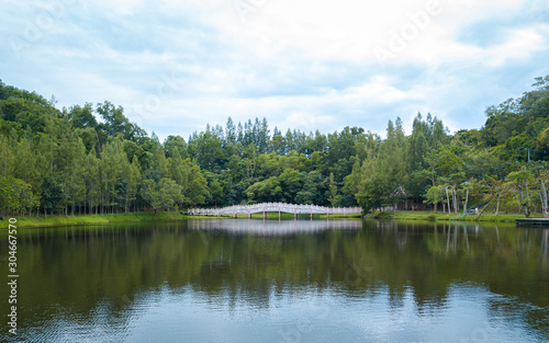 Stone bridge cross the river from forest coast to other with calm water and blue sky with nature around, Have refelction on the water