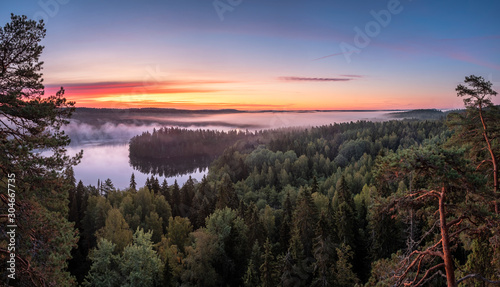 Scenic landscape with lake, sunrise and fog at tranquil misty morning in Aulanko, nature reserve, Finland