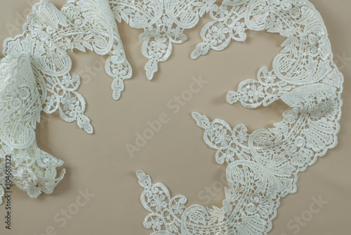Fototapeta Naklejka Na Ścianę i Meble -  Texture lace fabric. lace on white background studio. thin fabric made of yarn or thread. a background image of ivory-colored lace cloth. White lace on beige background.