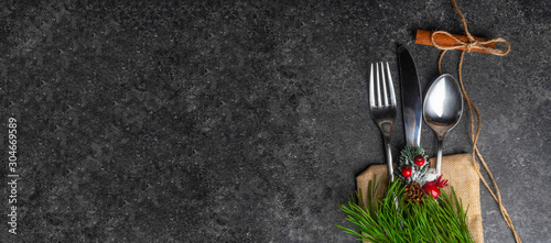 Christmas table place setting, cutlery in burlap bag with festive decorations star golden bow, pinecone with snow, green branch . Christmas Xmas New Year holiday background