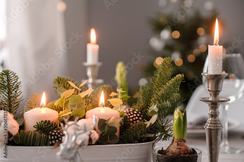 fragments of Christmas decor, cones, candles on the background of a decorated Christmas tree