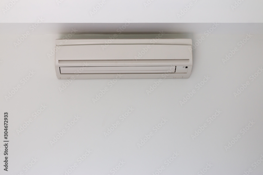 Air conditioner installed in a white concrete wall Air conditioner installed in a white concrete wall