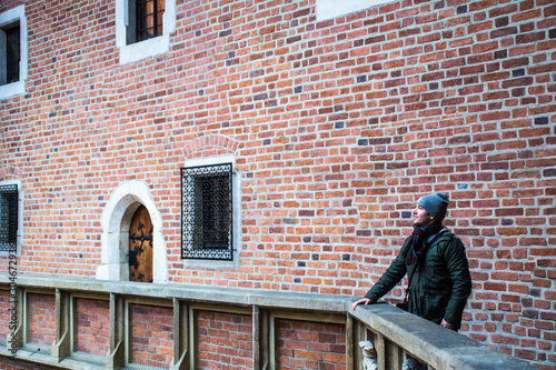 Profile of a young and cheerful boy at winter season contemplating the walls of Collegium Maius, part of the university where Nicolaus Copernicus and Juan Pablo II studied