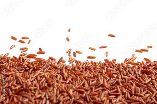 Red rice scattered on white background. Heap of uncooked dry rice grains