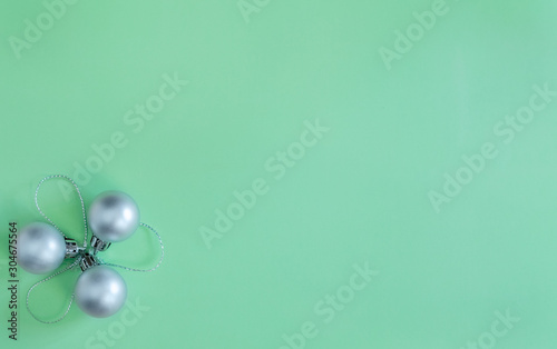 Christmas composition silver balls on a green background. Flat lay, New Year, top view, copy space, minimalism.