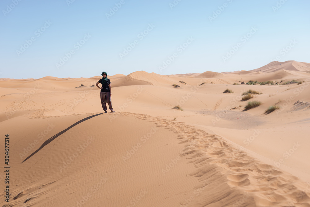 Woman looking at the horizon dunes in the Moroccan Sahara desert. Woman looking at the horizon dunes in the Moroccan Sahara desert.