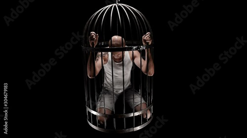 a person in a bird’s cage is held captive, raises his head and looks into the camera, maybe each of us is locked in his own cage 4K