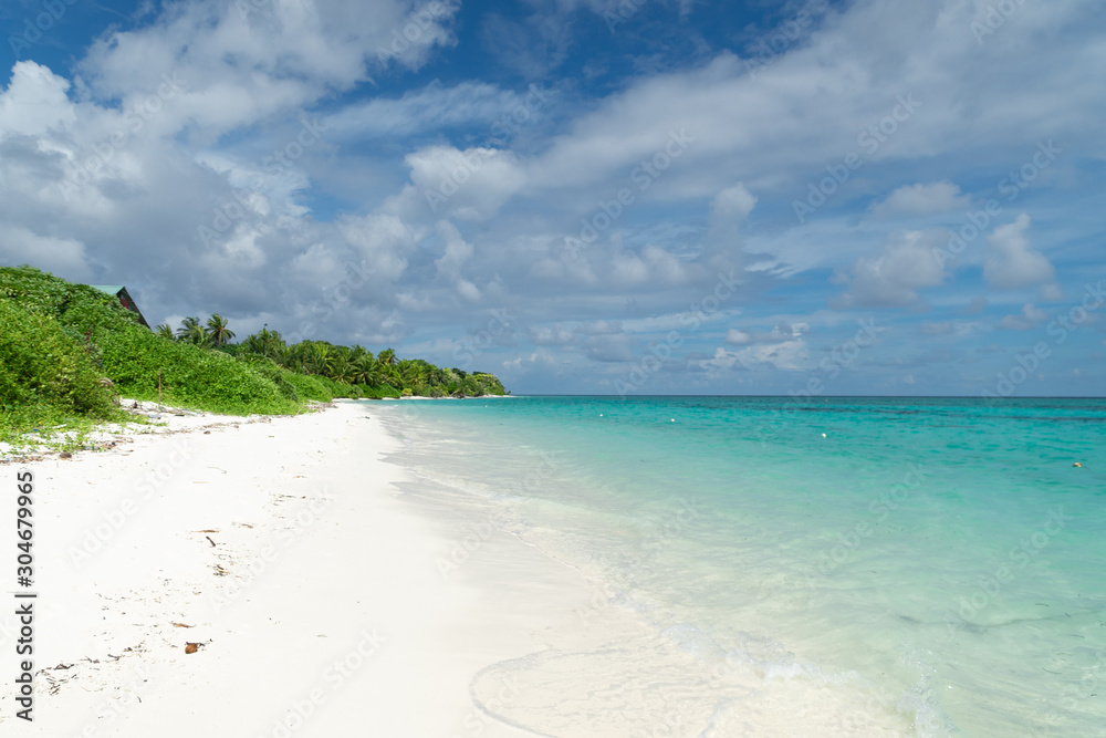 Separate view of a tropical island with turquoise sea, coconut palm trees and blue sky in the Maldives. Indian Ocean Sunset Separate view of a tropical island with turquoise sea, coconut palm trees and blue sky in the Maldives. Indian Ocean Sunset