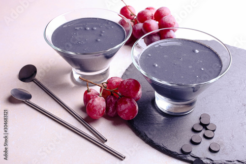 Black yogurt with activated carbon and red grapes photo