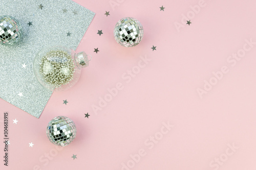 Holiday Christmas top view composition with silver xmas glass balls tree decorations and stars sparkles. Flat lay with copy space pink and silver tones