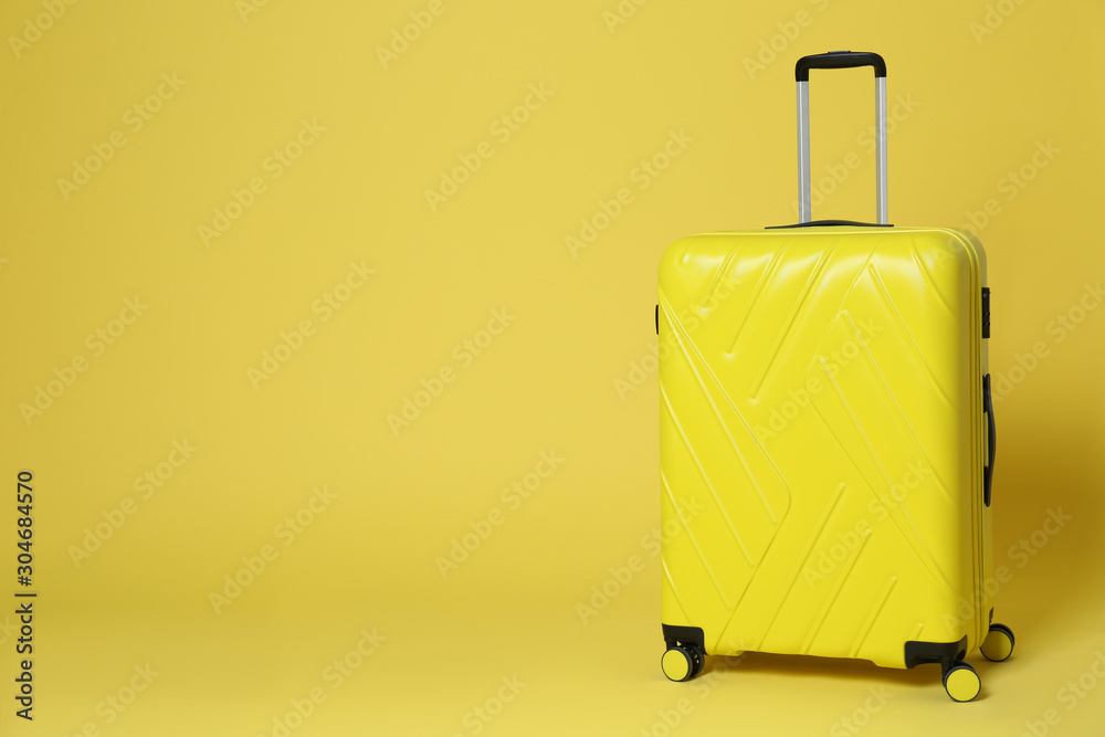Stylish suitcase on yellow background. Space for text Stylish suitcase on yellow background. Space for text