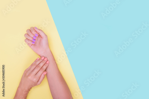 Bright manicure on yellow and mint backgrounds.