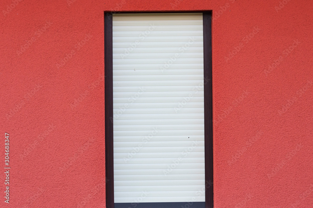 eine geschlossene Jalousie vor einem Fenster eine geschlossene Jalousie vor einem Fenster