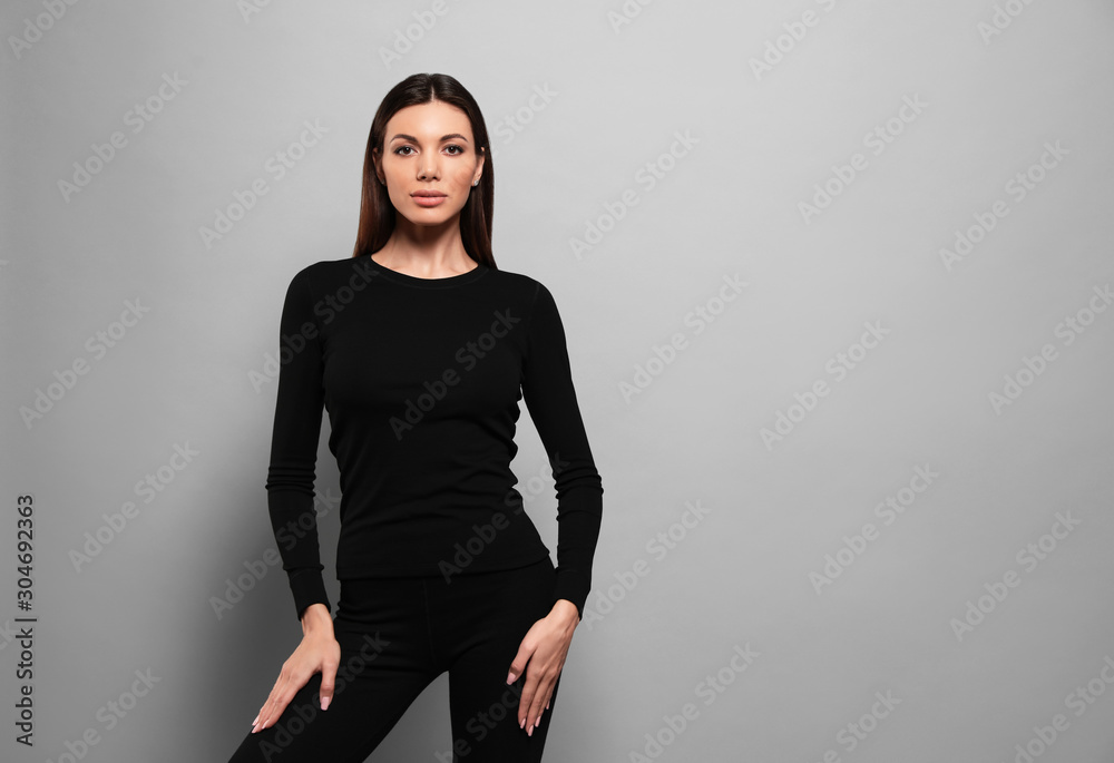 Woman wearing thermal underwear on grey background. Space for text Woman wearing thermal underwear on grey background. Space for text