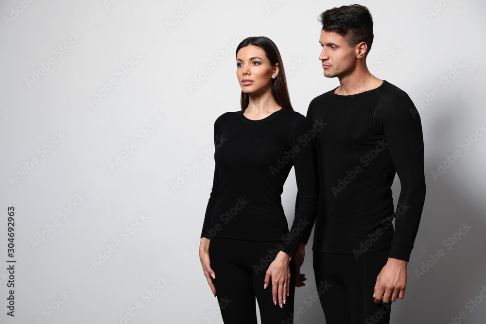 Couple wearing thermal underwear on light grey background. Space for text Couple wearing thermal underwear on light grey background. Space for text