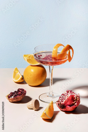 Summer cocktail with fresh pomegranate and lemon slices. Plug puller besides. Abstract studio conception.