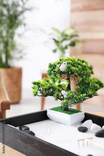 Beautiful miniature zen garden on wooden table indoors