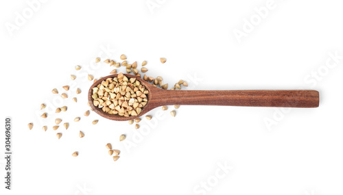 Uncooked green buckwheat grains in spoon isolated on white, top view