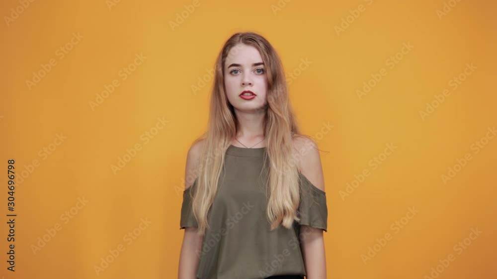 Portrait of confused young woman with looking so tired, yawning isolated on orange wall background in studio. People sincere emotions, lifestyle concept. Portrait of confused young woman with looking so tired, yawning isolated on orange wall background in studio. People sincere emotions, lifestyle concept.