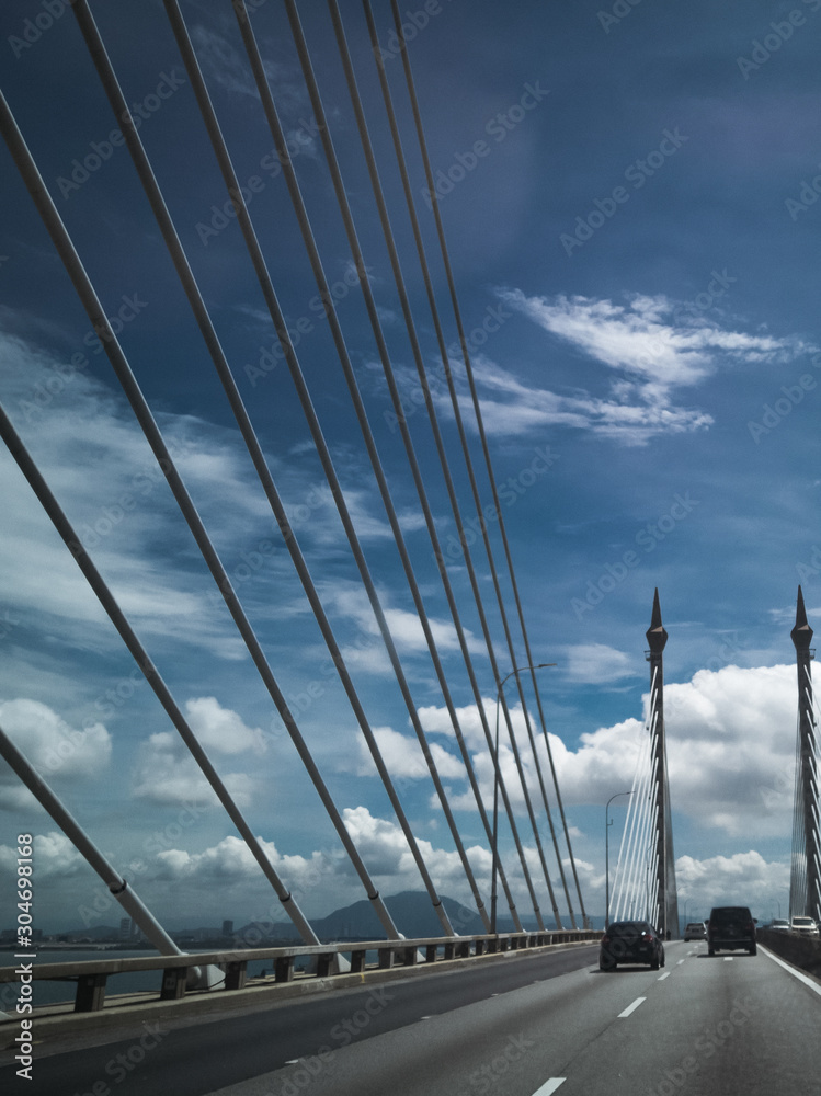 Obraz premium Towers of Bridge connecting George Town on Penang island and Seberang Prai on mainland of Malaysia through straits of Malacca.