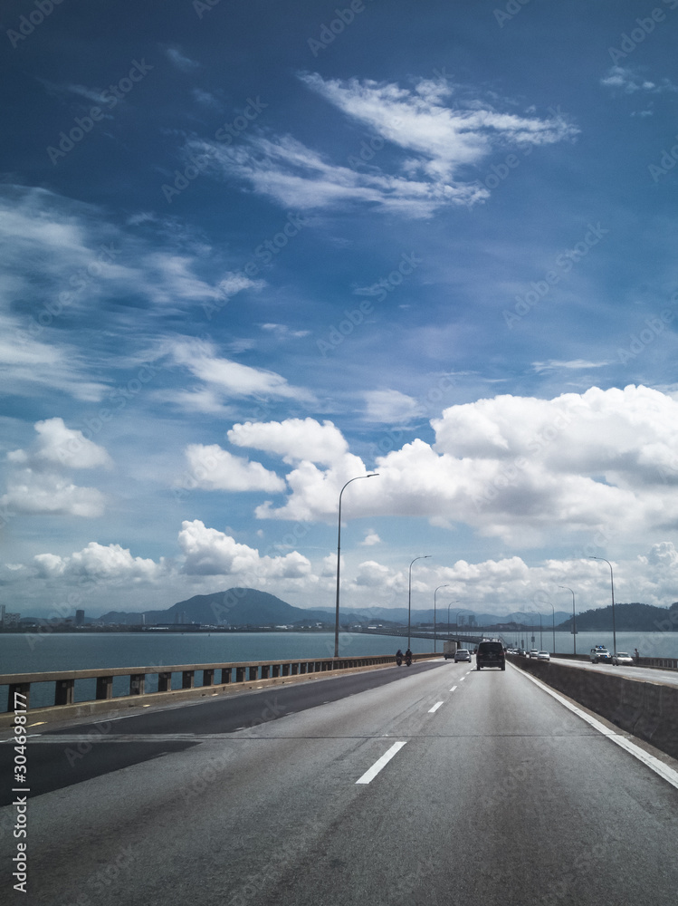 Fototapeta premium Towers of Bridge connecting George Town on Penang island and Seberang Prai on mainland of Malaysia through straits of Malacca.