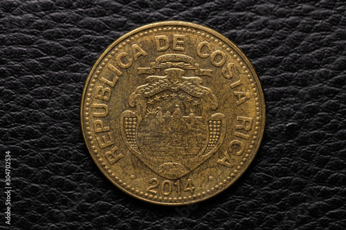 Costa Rican colones coin on black leather photo