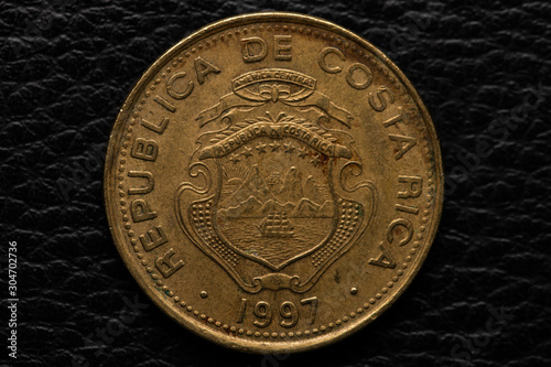 Costa Rican colones coin on black leather photo