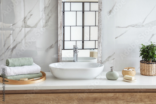 Modern bathroom interior with stylish mirror and vessel sink photo