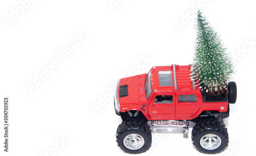 Red car carries a Christmas tree in the trunk . Toys. Christmas tree. New year and Christmas.