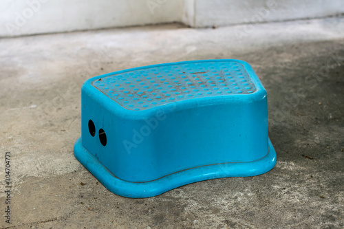 A dirty blue plastic step stool