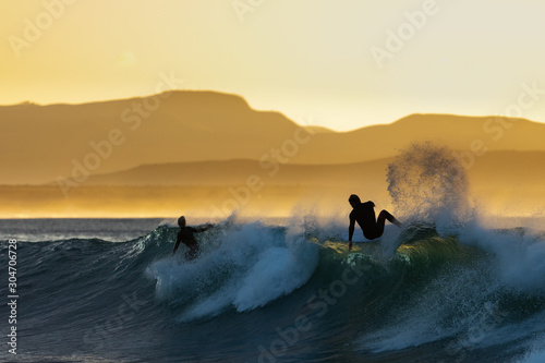 Surfers having fun at sunrise at Super Tubes in Jeffreys Bay, South Africa