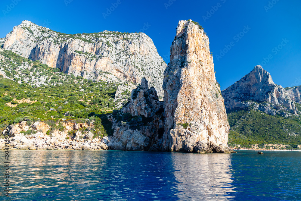 Fototapeta premium The monolith of Pedra Longa, Baunei, province of Ogliastra, East Sardinia, Italy. The rocky spire which rises majestically out of the sea. Holidays in Sardinia.