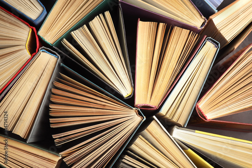 Many different hardcover books on dark background, top view