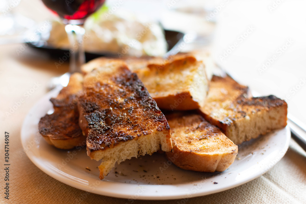 Greek food, roasted bread with olive oil and herbs, red wine and tzatziki sauce