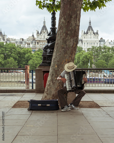 The Accordionist. An accordion player busking on the bank of the River Thames. photo