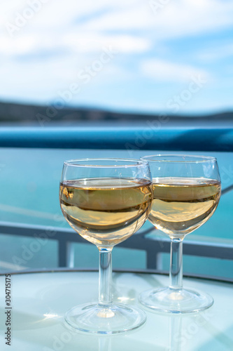 White wine served outside on balcony on glass table with sea view