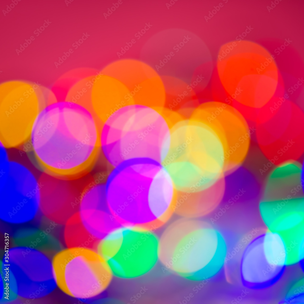 Colors yellow, red, purple, blue, green on a pink abstract blurred festive background.