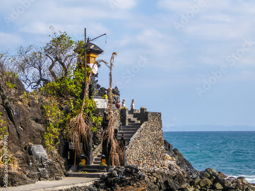 Hindu temple located at the very sea shore of Lombok Indonesia.The temple is a complex of small towers. There is a lot of trees overgrowing the area. Calmness and serenity. Religion joined with nature photo