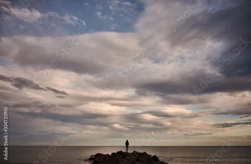 A man contemplates the Mediterranean Sea from the rocks of the Plage Baleine in Sète. France © JaviJfotografo
