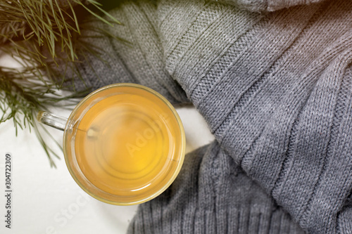 Cup of tea with a cozy wool background. Winter mood morning in a comfortable and warm atmosphere. Green tea for relaxation and positive moments.