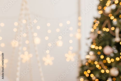 Beautiful holiday decorated room with Christmas tree and bright lights , out of focus shot for photo background. Blur christmas background photo