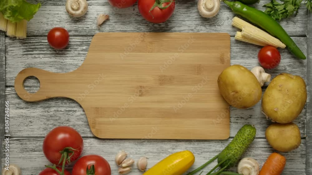Potato fruit rolls along a cutting board on a kitchen table with vegetables. The concept of vegetarian food. Raw vegetables are ready to cooking. Potato fruit rolls along a cutting board on a kitchen table with vegetables. The concept of vegetarian food. Raw vegetables are ready to cooking.