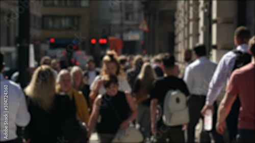 Busy London street in Sun and shadows people walking down, suits and tourists