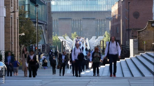 Zoom compressed population busy footbridge Timelaspse of people walking across London Millenium bridge