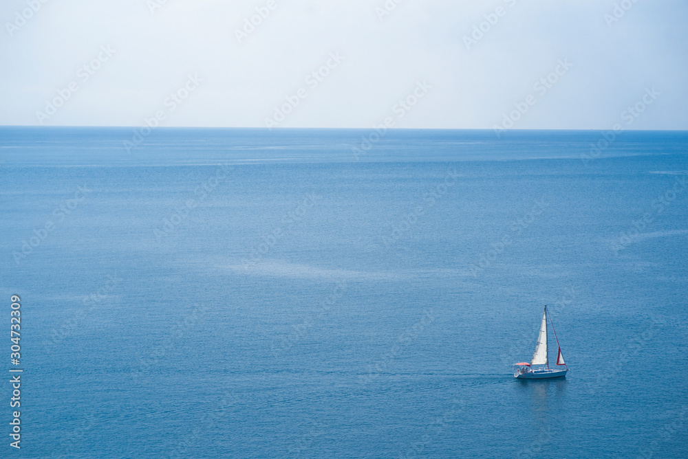 Sailboat in the middle of the beautiful sea in the daytime, holiday atmosphere in summer in Phuket, Thailand