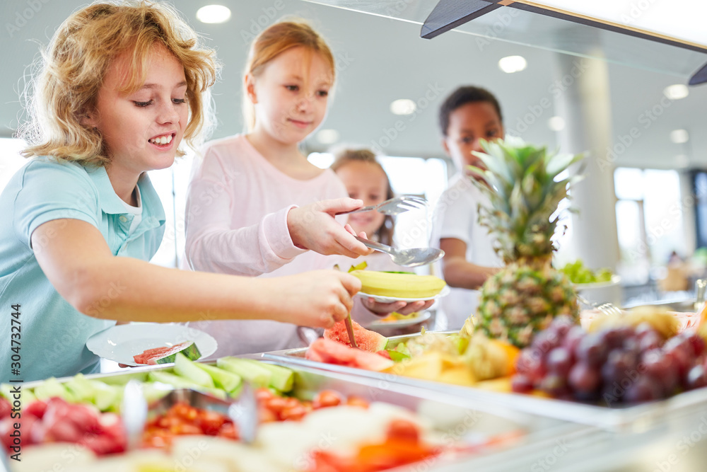 Students take fruits from the buffet