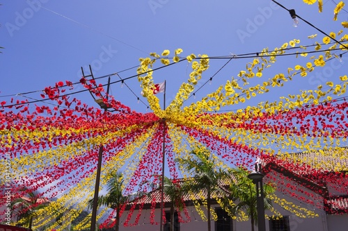 Decorations with red and yellow colored paper flowers in the square for a traditional festival (Sao Vicente, Madeira, Portugal)