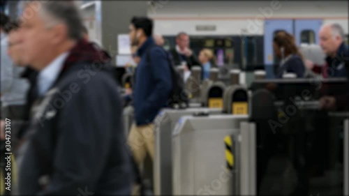 Handheld shot of people tapping out at a busy London station travelling to work